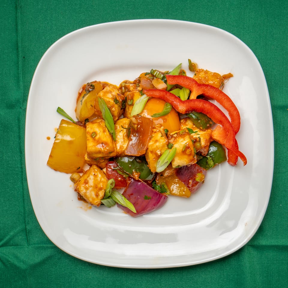 Chili Paneer, a vibrant Indian dish with paneer, bell peppers, and onions in a rich sauce.